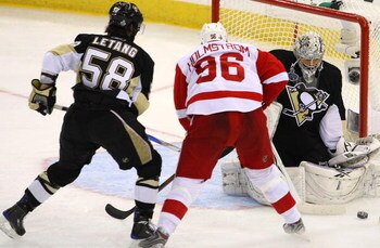 PITTSBURGH - JUNE 02:  Kris Letang #58 of the Pittsburgh Penguins defends against Tomas Holmstrom #96 of the Detroit Red Wings as goaltender Marc-Andre Fleury #29 saves a shot on goal during Game Three of the 2009 NHL Stanley Cup Finals on June 2, 2009 at