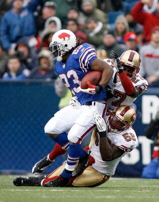 ORCHARD PARK, NY - NOVEMBER 30: Marshawn Lynch #23 of the Buffalo Bills is tackled by Walt Harris #27 and Patrick Willis #52 of the San Francisco 49ers  on November 30, 2008 at Ralph Wilson Stadium in Orchard Park, New York. The 49ers won 10-3.  (Photo by