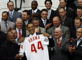 WASHINGTON - MAY 15: U.S. President Barack Obama holds up a Philadelphia Phillies jersey given to him by Jimmy Rollins (L) at the White House May 15, 2009 in Washington, DC. Obama welcomed Major League Baseball's 2008 World Champions to the White House an