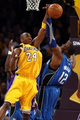 LOS ANGELES, CA - JUNE 04:  Kobe Bryant #24 of the Los Angeles Lakers reaches for a rebound against Dwight Howard #12 of the Orlando Magic in Game One of the 2009 NBA Finals at Staples Center on June 4, 2009 in Los Angeles, California. NOTE TO USER: User 