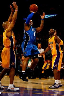 LOS ANGELES, CA - JUNE 04:  Jameer Nelson #14 of the Orlando Magic goes up for a shot over Derek Fisher #2 and Kobe Bryant #24 of the Los Angeles Lakers in Game One of the 2009 NBA Finals at Staples Center on June 4, 2009 in Los Angeles, California. NOTE 