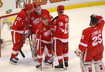 DETROIT - JUNE 06:  Goaltender Chris Osgood #30 of the Detroit Red Wings is congratulated by his teammates after a 5-0 win over the Pittsburgh Penguins in Game Five of the 2009 NHL Stanley Cup Finals at Joe Louis Arena on June 6, 2009 in Detroit, Michigan