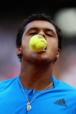 PARIS - JUNE 01:  Jo-Wilfried Tsonga of France bites a tennis ball during the Men's Single Fourth Round match against Juan Martin Del Potro of Argentina on day nine of the French Open at Roland Garros on June 1, 2009 in Paris, France.  (Photo by Ryan Pier