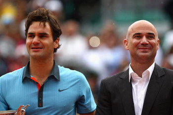 PARIS - JUNE 07: An emotional Roger Federer of Switzerland stands next to Andre Agassi following his victory during the Men's Singles Final match against Robin Soderling of Sweden on day fifteen of the French Open at Roland Garros on June 7, 2009 in Pari