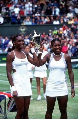 10 Jul 2000:  Venus Williams (left) of the USA and her sister and doubles partner Serena raise the trophy after they claimed victory in the womens doubles final during the Wimbledon Lawn Tennis Championship at the All England Lawn Tennis and Croquet Club,
