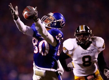 KANSAS CITY, MO - NOVEMBER 24:  Dezmon Briscoe #80 of the Kansas Jayhawks makes a catch as Justin Garrett #8 of the Missouri Tigers defends during the game at Arrowhead Stadium November 24, 2007 in Kansas City, Missouri.  (Photo by Jamie Squire/Getty Imag