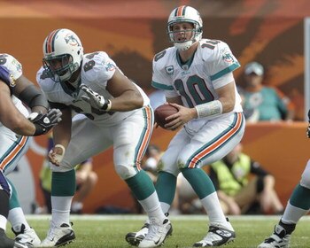 MIAMI, FL - JANUARY 4:  Quarterback Chad Pennington #10 of the Miami Dolphins takes a snap from center Samson Satele #64 against the Baltimore Ravens in an NFL Wildcard Playoff Game at Dolphins Stadium on January 4, 2009 in Miami, Florida.  (Photo by Al M