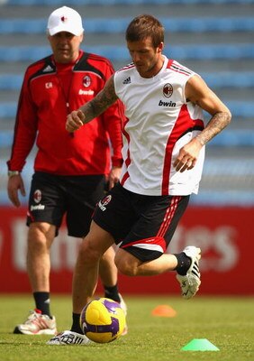 DUBAI, UNITED ARAB EMIRATES - JANUARY 04:  David Beckham (R) of AC Milan in action as Carlo Ancelotti (L), manager of AC Milan, looks on during a training session during the AC Milan Winter Training Camp at the Al Nasr Sports Club on January 4, 2009 in Du