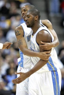 DENVER - DECEMBER 6:  Marcus Camby #23 bear hugs Nene #31 of the Denver Nuggets after putting up a run against Orlando Magic in the first half on December 6, 2004 at the Pepsi Center in Denver, Colorado.  NOTE TO USER: User expressly acknowledges and agre