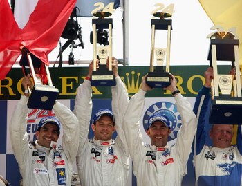LE MANS, FRANCE - JUNE 14:  Peugeot drivers Marc Gene, Alex Wurz and David Brabham celebrate on the podium after winning the Le Mans 24h race on June 14, 2009 in Le Mans, France.  (Photo by Bryn Lennon/Getty Images)