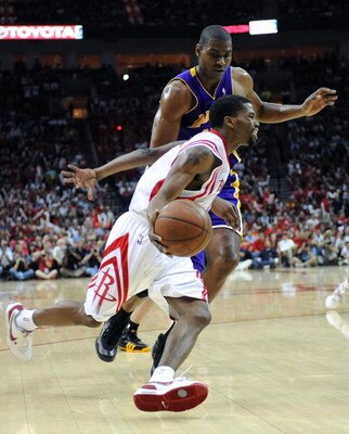 HOUSTON - MAY 10:  Guard Aaron Brooks #0 of the Houston Rockets dribbles the ball past Andrew Bynum #17 of the Los Angeles Lakers in Game Four of the Western Conference Semifinals during the 2009 NBA Playoffs at Toyota Center on May 10, 2009 in Houston, T
