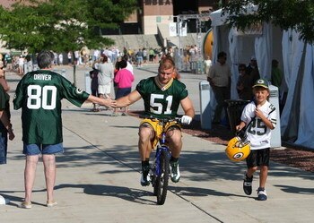 GREEN BAY, WI - JULY 28: Brady Poppinga #51 of the Green Bay Packers shakes hands with a fan as he rides a bicycle to practice before a summer training camp practice on July 28, 2008 at the Hutson Center in Green Bay, Wisconsin. (Photo by Jonathan Daniel/