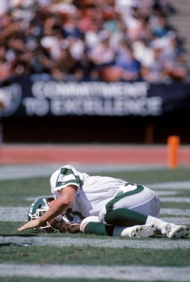 LOS ANGELES, CA - SEPTEMBER 8:  Quarterback Ken O'Brien #7 of the New York Jets needs a moment to get up during a game against the Los Angeles Raiders at the Los Angeles Memorial Coliseum on September 8, 1985 in Los Angeles, California.  The Raiders won 3