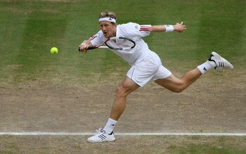LONDON - JULY 07:  Jonas Bjorkman of Sweden stretches for teh forehand against Roger Federer of Switzerland in their semi-final during day eleven of the Wimbledon Lawn Tennis Championships at the All England Lawn Tennis and Croquet Club on July 7, 2006 in