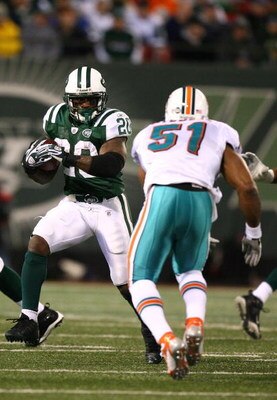 EAST RUTHERFORD, NJ - DECEMBER 28:  Thomas Jones #20 of The New York Jets runs the ball as Akin Ayodele #51 of The Miami Dolphins attempts the tackle during their game on December 28, 2008 at Giants Stadium in East Rutherford, New Jersey.  (Photo by Al Be