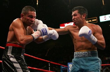 LAS VEGAS - SEPTEMBER 17:  Marco Antonio Barrera (R) lands a right against Robbie Peden as he gets knocked back in the WBC-IBF Unification Super Featherweight World Title fight at the MGM Grand Garden Arena on September 17, 2005 in Las Vegas, Nevada. Barr