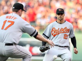 BOSTON - JULY 12:  Nick Markakis #21 of the Baltimore Orioles pauses as he thinks Aubrey Huff #17 is going to get the ball on July 12, 2008 at Fenway Park in Boston, Massachusetts. Mike Lowell of the Boston Red Sox arrived safely at first base on the play