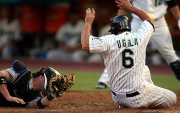 MIAMI - JULY 30:  Dan Uggla #6 of the Florida Marlins avoids a tag by catcher Brian Schneider #23 of the New York Mets in the third inning on July 30, 2008 at Dolphin Stadium in Miami, Florida.  The Marlins defeated the Mets 7-4.  (Photo by Marc Serota/Ge
