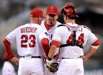 ANAHEIM, CA - APRIL 22:  Pitcher Joe Sauders #51 (C) of the Los Angeles Angels reacts as he get a visit from pitching coach Mike Butcher #23  while catcher Mike Napoli #44 loooks on after Saunders gave up a run to the Detroit Tigers during the first innin