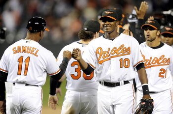 BALTIMORE - APRIL 06:  Adam Jones #10 of the Baltimore Orioles celebrates with Juan Samuel #11 after a 10-5 victory against the New York Yankees during opening day on April 6, 2009 at Camden Yards in Baltimore, Maryland.  (Photo by Greg Fiume/Getty Images