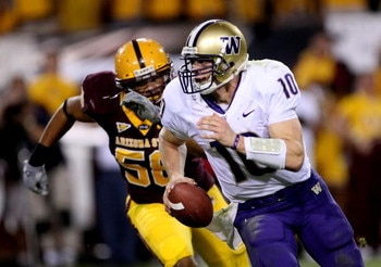 TEMPE, AZ - OCTOBER 13:  Quarterback Jake Locker #10 of the Washington Huskies runs away from the pursuit of linebacker Dexter Davis #58 of the Arizona State Sun Devils on October 13, 2007 at Sun Devil Stadium in Tempe, Arizona.  Arizona State won 44-20. 