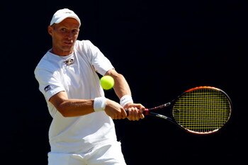 WIMBLEDON, ENGLAND - JUNE 23:  Nikolay Davydenko of Russia plays a backhand during the men's singles first round match against Daniel Evans of Great Britain on Day Two of the Wimbledon Lawn Tennis Championships at the All England Lawn Tennis and Croquet C