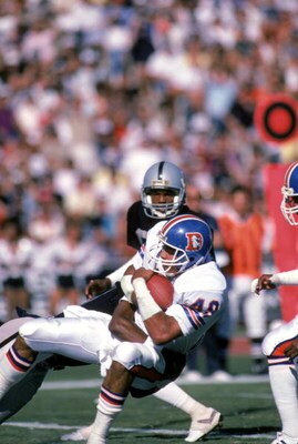 LOS ANGELES - NOVEMBER 2:  Safety Dennis Smith #49 of the Denver Broncos catches a pass during a game against the Los Angeles Raiders at the Los Angeles Memorial Coliseum on November 2, 1986 in Los Angeles, California.  The Broncos won 21-10.  (Photo by G