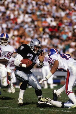 LOS ANGELES - DECEMBER 4:  Running back Bo Jackson #34 of the Los Angeles Raiders looks to make a move against Denver Broncos safety Dennis Smith #49 during a game at the Los Angeles Memorial Coliseum on December 4, 1988 in Los Angeles, California. The Ra