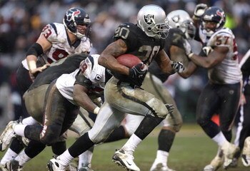 OAKLAND, CA - DECEMBER 21:  Johnnie Lee Higgins #15 of the Oakland Raiders returns a punt for an 80 yard touchdown as Dominique Barber #34 of the Houston Texans defends during an NFL game on December 21, 2008 at the Oakland-Alameda County Coliseum in Oakl