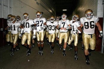 LOS ANGELES, CA - NOVEMBER 29:  Quarterback Jimmy Clausen #7 of the Notre Dame Fighting Irish walks out with teammates Robert Hughes #33 and Sergio Brown #31 before the game against the USC Trojans at Los Angeles Memorial Coliseum on November 29, 2008 in 