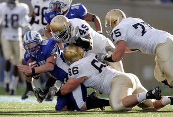 AIR FORCE ACADEMY, CO - NOVEMBER 11:  Defensive linemen Derek Landri #66, Chris Frome #75 and linebacker Tiryan Smith #49 of the Notre Dame Fighting Irish bring down quarterback Shaun Carney #5 of the Air Force Falcons in the second quarter on November 11