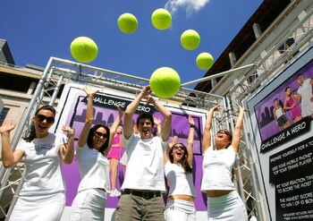 LONDON, ENGLAND - JUNE 23:  WTA staff throw balls in the air to celebrate an interactive mobile tennis game on a giant plasma screen during which passers by can challenge No 7 Vera Zvonareva in the WTA live digital gaming event at Covent Garden during Wim
