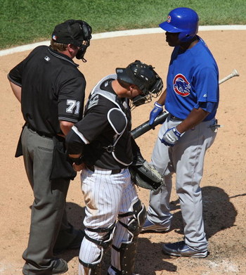 CHICAGO - JUNE 28: Milton Brandley #21 of the Chicago Cubs asks for the count from home plate umpire Brain Runge #71 as A.J. Pierzynski #12 of the Chicago White Sox listens on June 28, 2009 at U.S. Cellular Field in Chicago, Illinois. The White Sox defea
