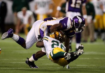 MINNEAPOLIS - NOVEMBER 09:  Adrian Peterson #29 of the Minnesota Vikings is tackled after a carry by linebacker safety Atari Bigby #20 of the Green Bay Packers on November 9, 2008 at the Metrodome in Mineapolis, Minnesota.  The Vikings won 28-27.  (Photo 