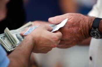 ST PETERSBURG, FL - OCTOBER 22:  A fan holds tickets and another holds money before the Philadelphia Phillies take on the Tampa Bay Rays during game one of the 2008 MLB World Series on October 22, 2008 at Tropicana Field in St. Petersburg, Florida.  (Phot
