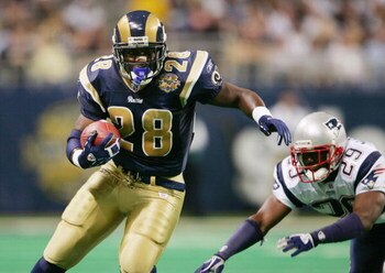 ST. LOUIS - NOVEMBER 7:   Running back Marshall Faulk #28 of the St. Louis Rams runs upfield against the New England Patriots on November 7, 2004 at the Edward Jones Dome in St. Louis, Missouri. The Patriots defeated the Rams 40-22. (Photo by Elsa/Getty I