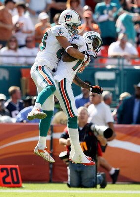 MIAMI - NOVEMBER 23:  Wide receiver Greg Camarillo #83 of the Miami Dolphins celebrates with Ted Ginn Jr. #19 after his touchdown catch in the first quarter against the New England Patriots at Dolphin Stadium on November 23, 2008 in Miami, Florida.  (Phot
