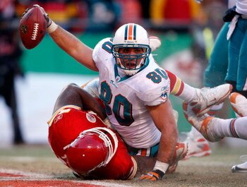 KANSAS CITY, MO - DECEMBER 21:  Receiver Anthony Fasano #80 of the Miami Dolphins raises the ball after scoring the game-winning touchdown as Tank Tyler #93 of the Kansas City Chiefs defends during the game on December 21, 2008 at Arrowhead Stadium in Kan