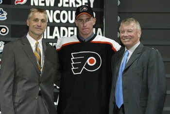 NASHVILLE, TN - JUNE 21:  (L to R) Paul Holmgren, first round draft pick (#11 overall), Jeff Carter, Bob Clarke of the Philadelphia Flyers pose for a portrait on stage during the 2003 NHL Entry Draft at the Gaylord Entertainment Center on June 21, 2003 in