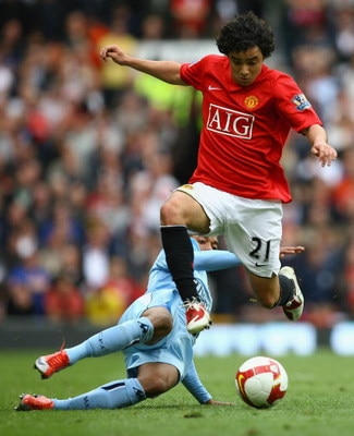 MANCHESTER, ENGLAND - MAY 10:  Rafael of Manchester United hurdles the tackle of Robinho of Manchester City during the Barclays Premier League match between Manchester United and Manchester City at Old Trafford on May 10, 2009 in Manchester, England.  (Ph