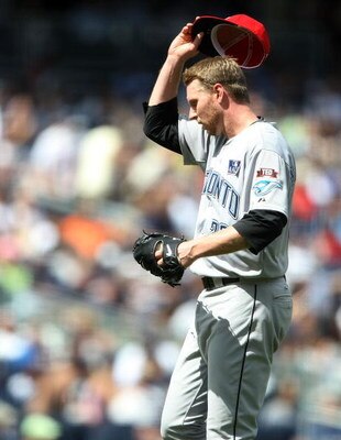 NEW YORK - JULY 04:  Roy Halladay #32 of the Toronto Blue Jays removes his hat against the New York Yankees on July 4, 2009 at Yankee Stadium in the Bronx borough of New York City.  (Photo by Nick Laham/Getty Images)