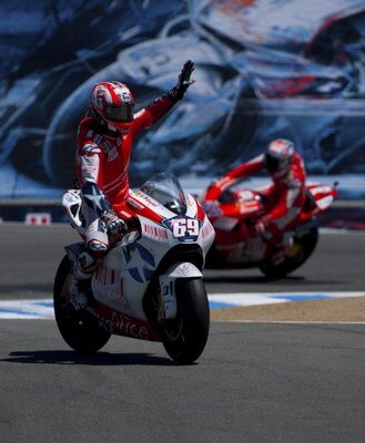 MONTEREY, CA - JULY 5:  Nicky Hayden rider of the #69 Ducati waves to the crowd as his teamate Casey Stoner rides in the background after the Moto GP Red Bull U. S. Grand Prix at the Mazda Raceway Laguna Seca on July 5, 2009 in Monterey, California.  (Pho
