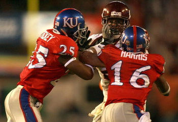 MIAMI - JANUARY 03:  Branden Ore #28 of the Virginia Tech Hokies is pushed out of bounds by Chris Harris #16 and Darrell Stuckey #25 of the Kansas Jayhawks during the FedEx Orange Bowl at Dolphin Stadium on January 3, 2008 in Miami, Florida.  (Photo by Do
