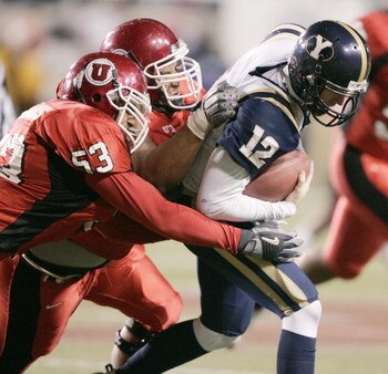 SALT LAKE CITY, UT - NOVEMBER 20: Taylor Miller #53 and Sione Pouha #90 of University of Utah sack John Beck #12 of BYU late in the fourth quarter November 20, 2004 at Rice Eccles Stadium in Salt Lake City, Utah. (Photo by George Frey/Getty Images)