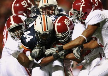 AUBURN, AL - NOVEMBER 24:  Running back Ben Tate #44 of the Auburn Tigers drags a group of Alabama Crimson Tide defenders at Jordan-Hare Stadium on November 24, 2007 in Auburn, Alabama.   (Photo by Doug Benc/Getty Images)
