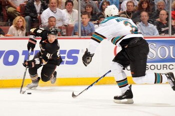 ANAHEIM, CA - APRIL 21:  Andrew Ebbett #48 of the Anaheim Ducks skates with the puck against Douglas Murray #3 of the San Jose Sharks during Game Three of the Western Conference Quarterfinal Round of the 2009 Stanley Cup Playoffs at Honda Center on April 
