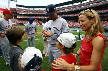 ST LOUIS, MO - JULY 14:  Derek Jeter of the New York Yankees signs autographs for young fans as musician Sheryl Crow looks on before the 2009 MLB All-Star Game at Busch Stadium on July 14, 2009 in St Louis, Missouri.  (Photo by Jamie Squire/Getty Images)