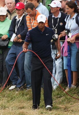 TURNBERRY, SCOTLAND - JULY 16:  Tiger Woods of USA lifts a cable on the 3rd hole during round one of the 138th Open Championship on the Ailsa Course, Turnberry Golf Club on July 16, 2009 in Turnberry, Scotland.  (Photo by Warren Little/Getty Images)