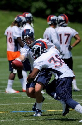 ENGLEWOOD, CO - JUNE 12:  Quarterback Kyle Orton #8 of the Denver Broncos hands the ball off to running back Kestahn Moore #38 during minicamp practice at the Broncos Dove Valley training facility on June 12, 2009 in Englewood, Colorado.  (Photo by Doug P
