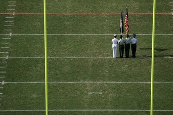 CHARLOTTESVILLE, VA - SEPTEMBER 25:  The US flag is held aloft during the game between the Virginia Cavaliers and the Syracuse Orangemen at Scott Stadium on September 25, 2004 in Charlottesville, Virginia. Virginia won 31-10. (Photo by Doug Pensinger/Gett